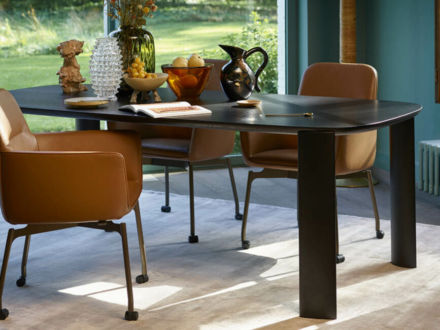 Leolux Tico tafel met leren stoelen in een eetkamer met groene wand