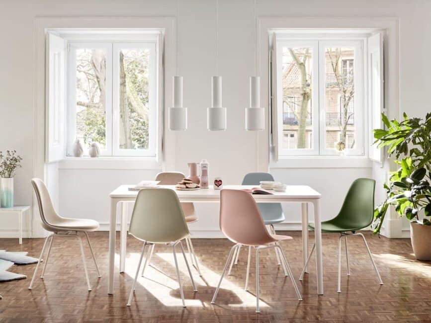 Vitra Eames stoelen in pastelkleuren aan een witte tafel