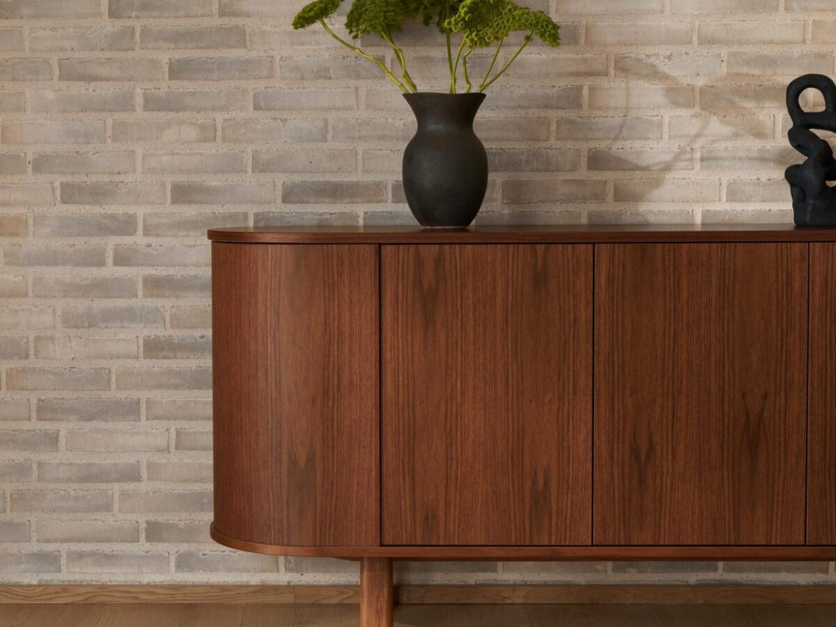 Skovby #543 walnoot dressoir tegen een bakstenen muur met vaas