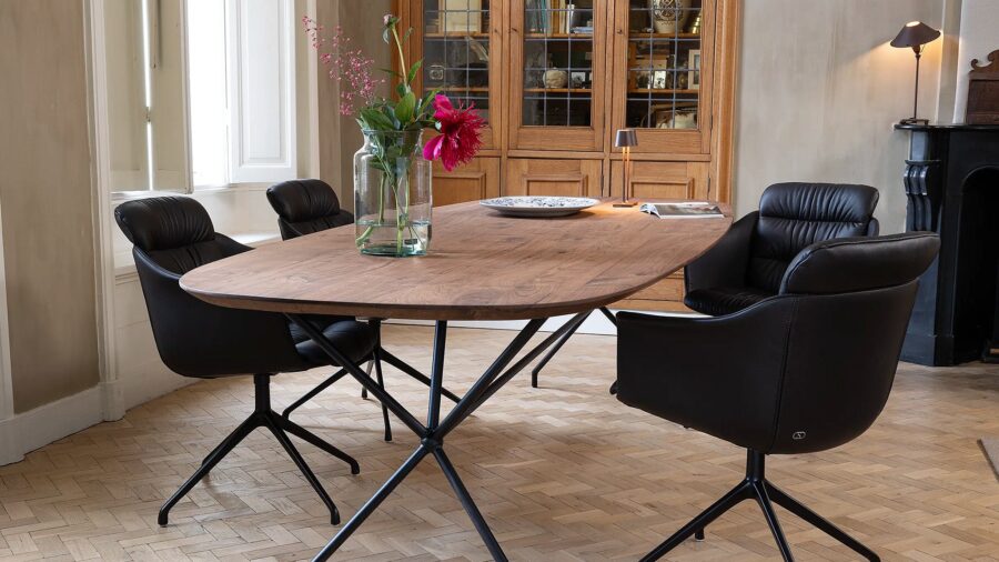 De Sede DS-525 eetkamerstoelen in zwart leer aan een ovale houten tafel